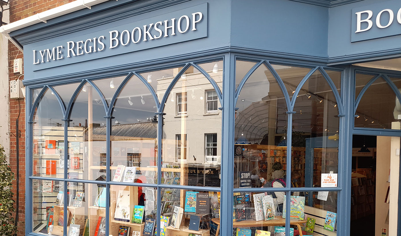 The blue Gothic-arched shopfront of Lyme Regis Bookshop at 11 Broad Street, the same frontage that appeared in the 1981 film The French Lieutenant's Woman
